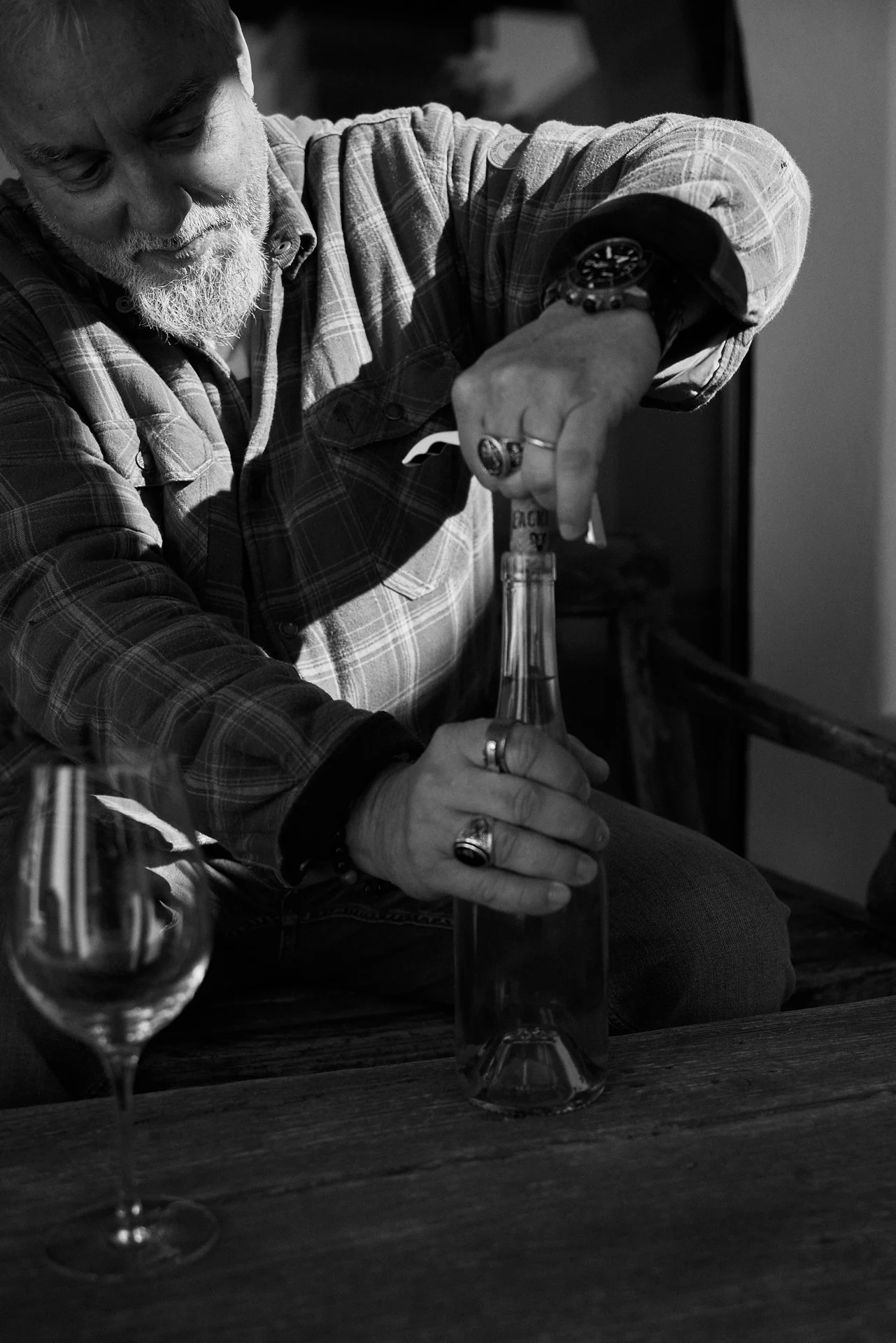 Peter Lehner pulling the cork from a bottle of Podenco Loco wine during an estate tasting, captured in a detailed close-up