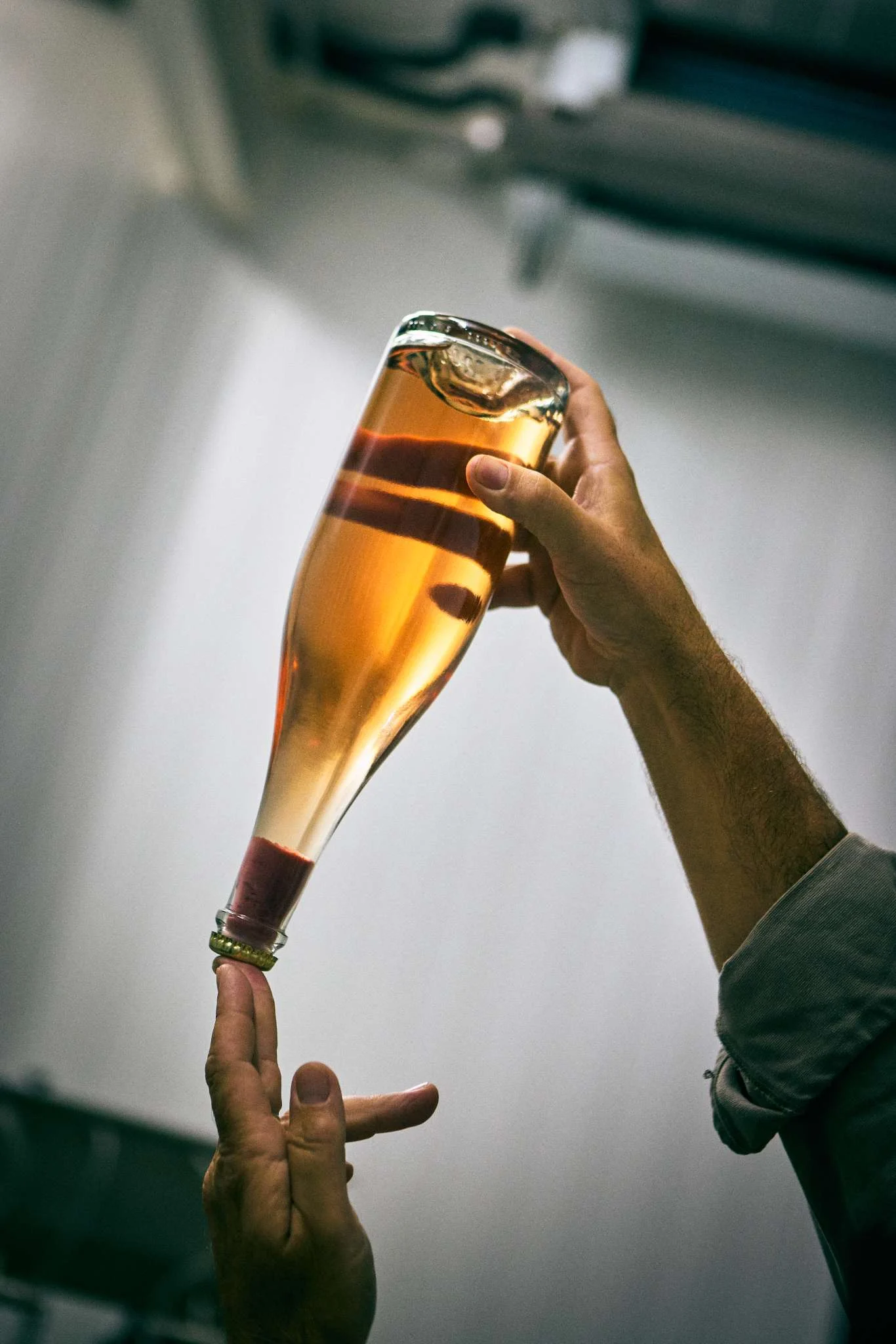 Artisanal sparkling wine bottle being inspected for sediment at Toni Xumeu's Can Vinya winery in Ibiza, a key collaborative cellar space for Peter Lehner's upcoming vintages.